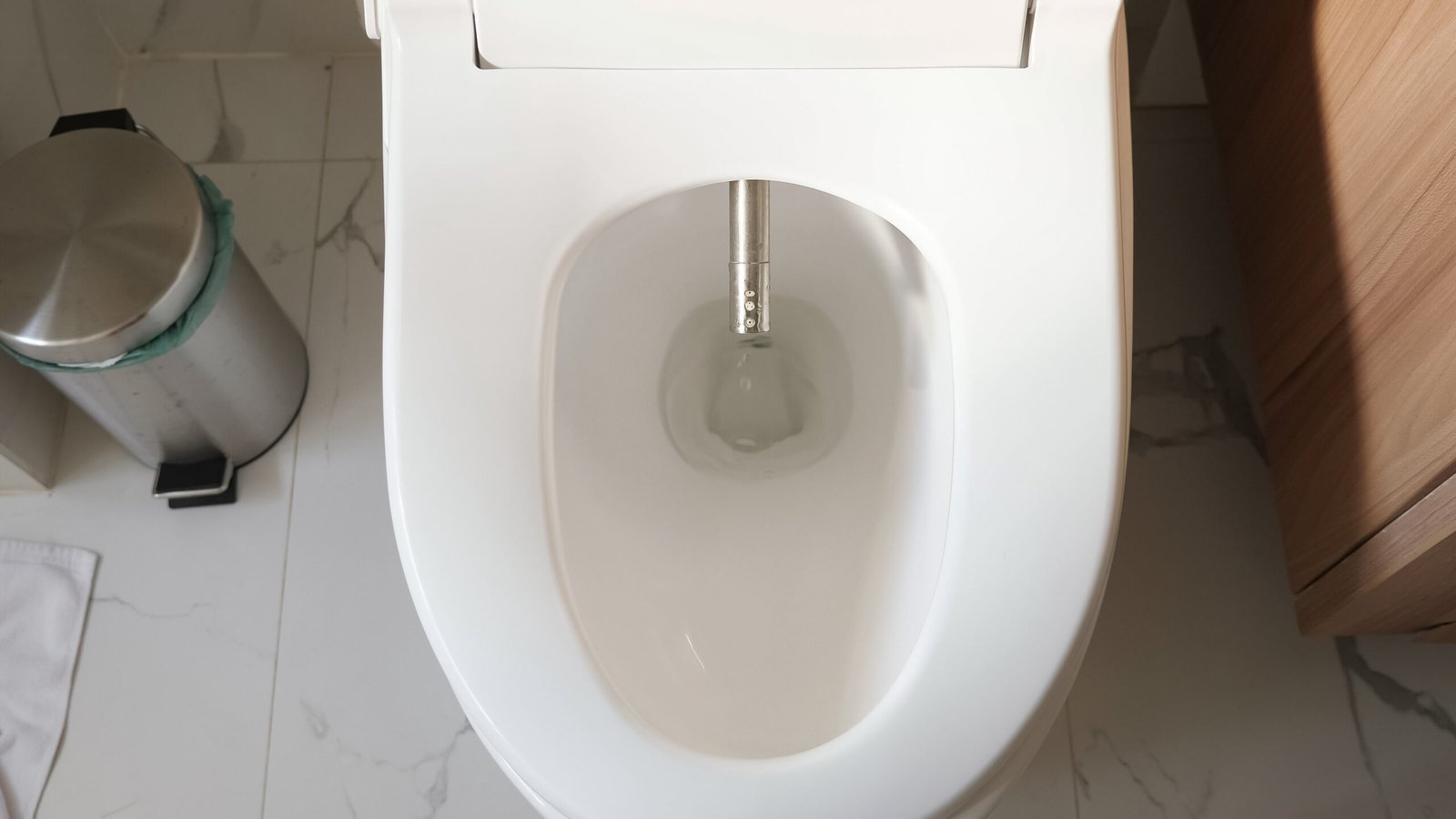 modern silver bidet injector appears in white flush near bin